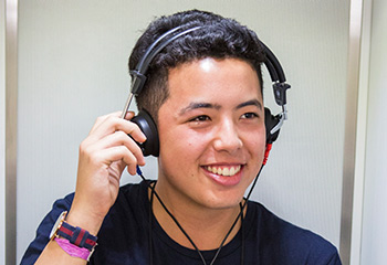 Smiling student listening to music using headphones