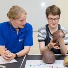 Girls looking at various skulls as part of the STEM Explorer program