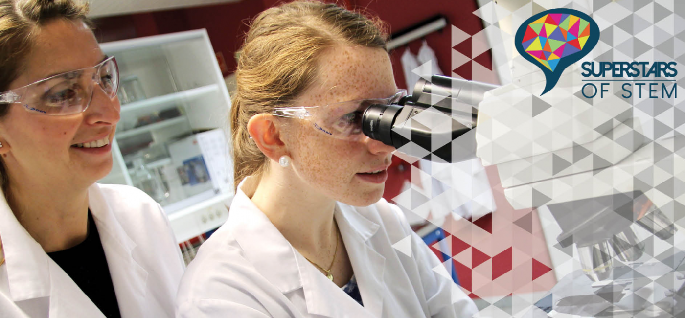 Young girls looking into microscope