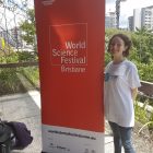 Lady standing next to a 'World Science Festival' banner in Brisbane
