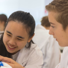 Two students are looking at a model of a human skull